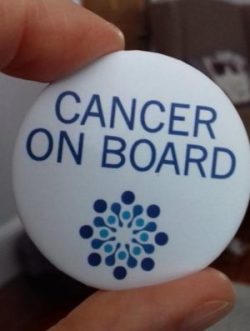 Person holding a Cancer On Board badge